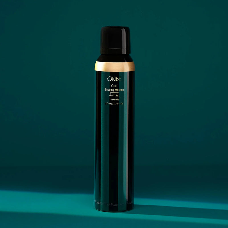 Oribe Curl Shaping Mousse in gold aerosol can — a lightweight, moisturizing mousse that defines curls, controls frizz, and adds soft hold without crunch.