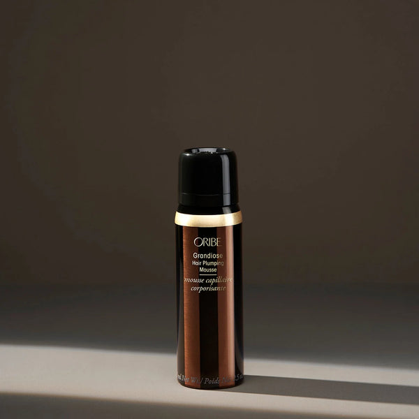 Oribe Grandiose Hair Plumping Mousse travel-size — a lightweight, volumizing mousse that adds body, bounce, and structure to fine or flat hair while maintaining soft, touchable movement.