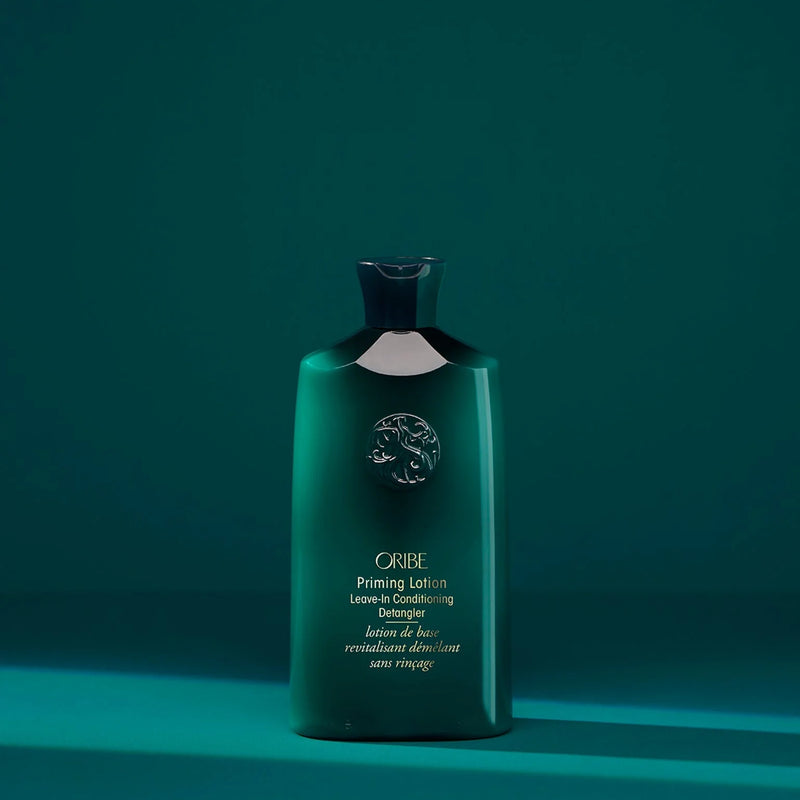 Oribe Priming Lotion Leave-In Conditioning Detangler in a luxe blush-toned tube — a silky, ultra-hydrating leave-in formula that detangles, conditions, and preps curly or coily hair for styling.