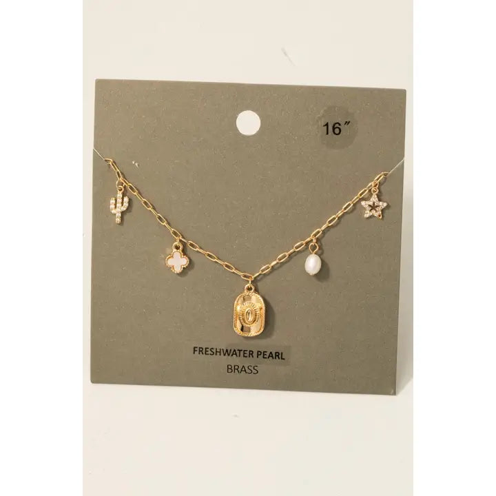 Charms are trending and this boho chic CZ pearl and shell Western theme charms necklace is so fun! Featuring cubic zirconia pearls, shell accents, and adjustable chain.