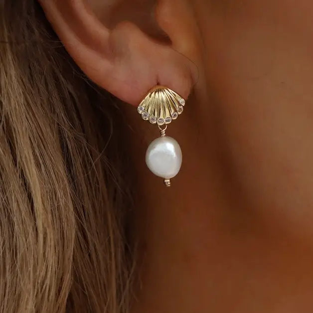 From Katie Waltman these Seaside Shell Pearl Studs are an Elegant shell pearl studs with a beautiful seaside-inspired design, perfect for adding a touch of coastal charm to any outfit. These timeless earrings offer a sophisticated, minimalist look, ideal for everyday wear or special occasions. These would make a lovely, thoughtful gift.