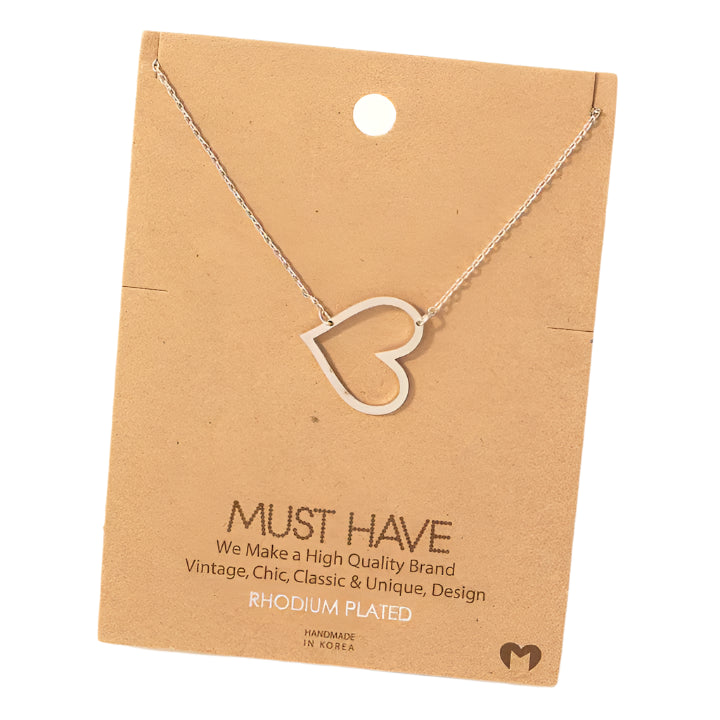 A must have, trendy and chic necklace. This has a unique and fun style, cute to wear alone or layered. Featured in a silver, rhodium plated option, tilted heart cut-out necklace on delicate gold chain, modern and stylish heart jewelry.