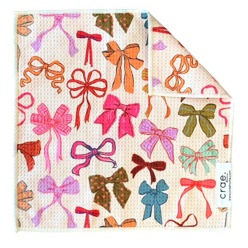 Crae Home Perfectly Tied reversible dishcloth – a lovely variety of bows on a waffle‑weave microfiber towel in cream, double‑sided for kitchen or bath.