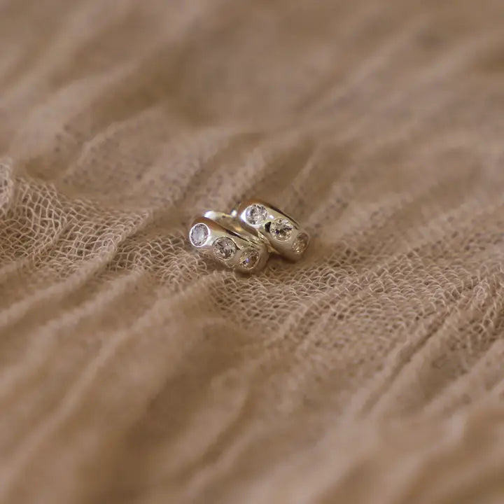 Katie Waltman Maeve Huggies in silver – dainty silver-plated hoop earrings featuring a single sparkling cubic zirconia accent.