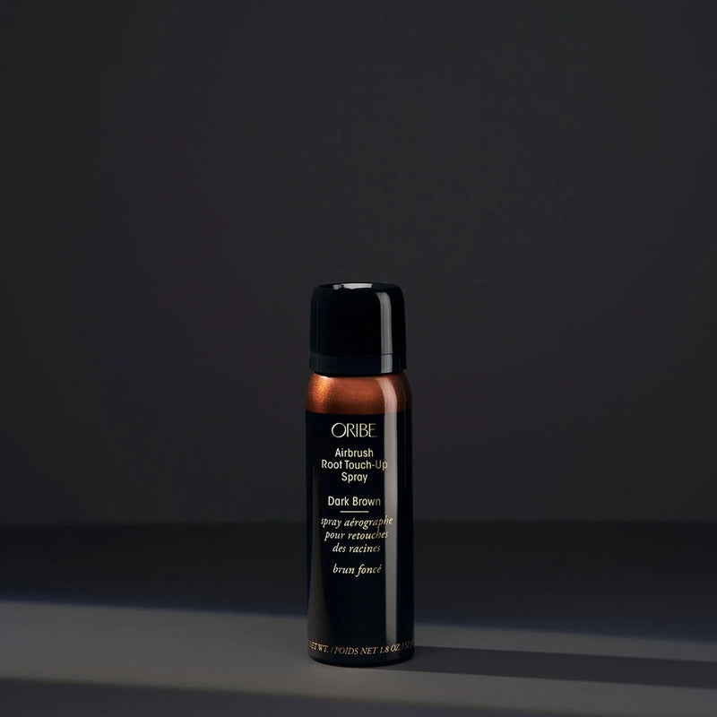 Oribe Airbrush Root Touch-Up Spray in Dark Brown – slim black aerosol can with dark brown cap and upper panel, gold logo, and microfine powder formula for seamless root coverage.
