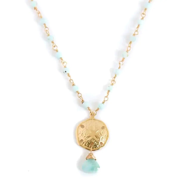 Amy Joy Sophie Larimar Necklace featuring a gold sand dollar pendant with a teardrop larimar stone on a beaded gold chain.